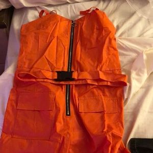 Orange jumpsuit with belt.
